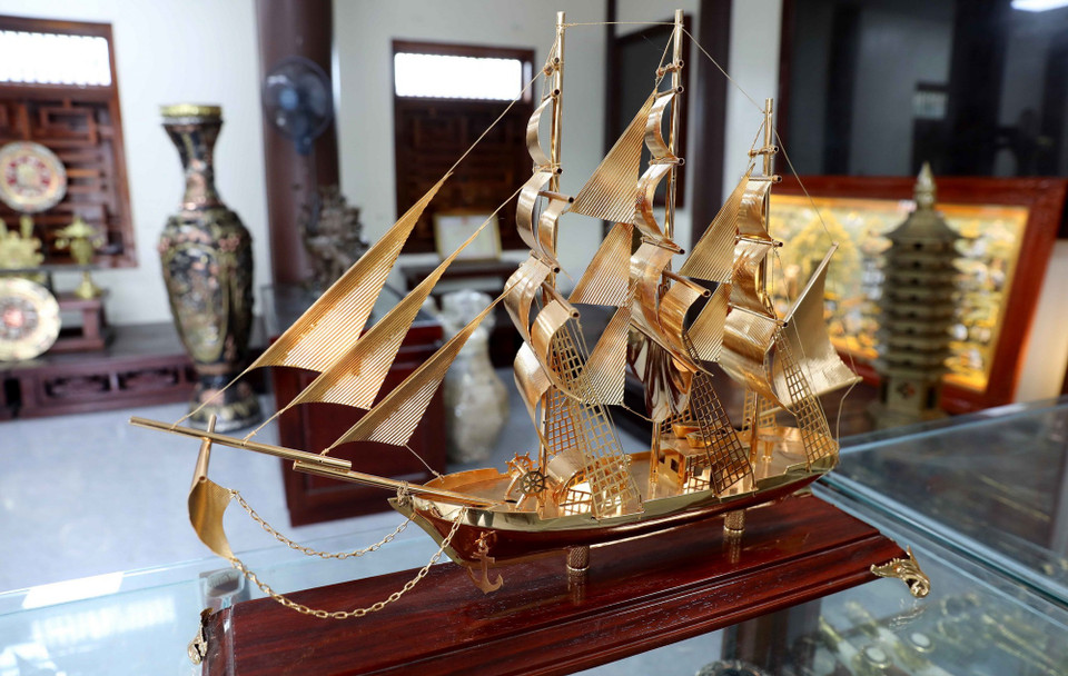 Tác phẩm “Thuận buồm xuôi gió” của làng nghề chạm bạc Đồng Xâm hút khách dịp Tết. (Ảnh: Thế Duyệt/TTXVN)