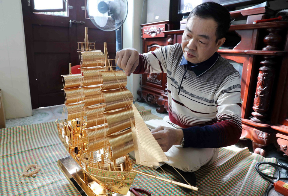 Hoàn thiện tác phẩm “Thuận buồm xuôi gió” của làng nghề chạm bạc Đồng Xâm. (Ảnh: Thế Duyệt/TTXVN)