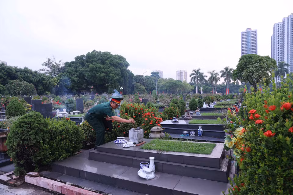 Thắp hương trên phần mộ liệt sỹ tại Nghĩa trang Mai Dịch (phường Phú Diễn). (Ảnh: Văn Điệp/TTXVN) ​