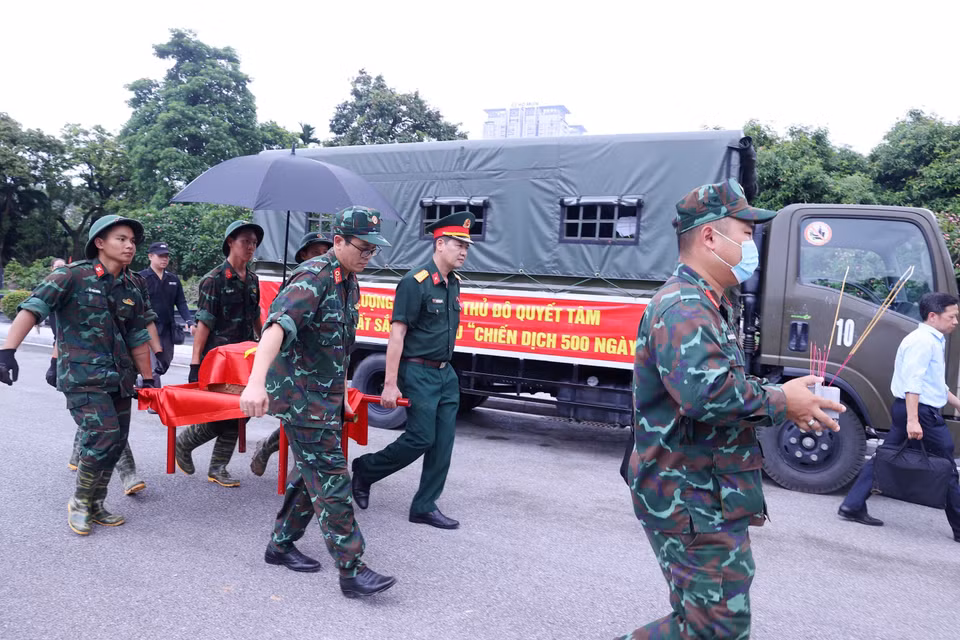 Khai quật, đưa hài cốt liệt sỹ chưa xác định danh tính về khu vực lấy mẫu sinh phẩm tại Nghĩa trang Mai Dịch (phường Phú Diễn). (Ảnh: Văn Điệp/TTXVN) ​ ​ ​