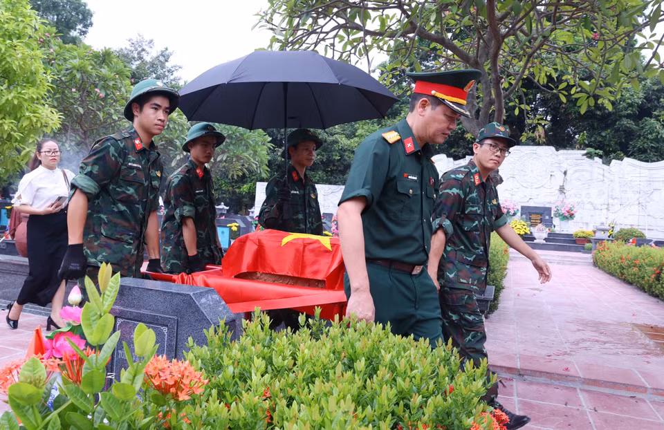 Khai quật, đưa hài cốt liệt sỹ chưa xác định danh tính về khu vực lấy mẫu sinh phẩm tại Nghĩa trang Mai Dịch (phường Phú Diễn). (Ảnh: Văn Điệp/TTXVN)