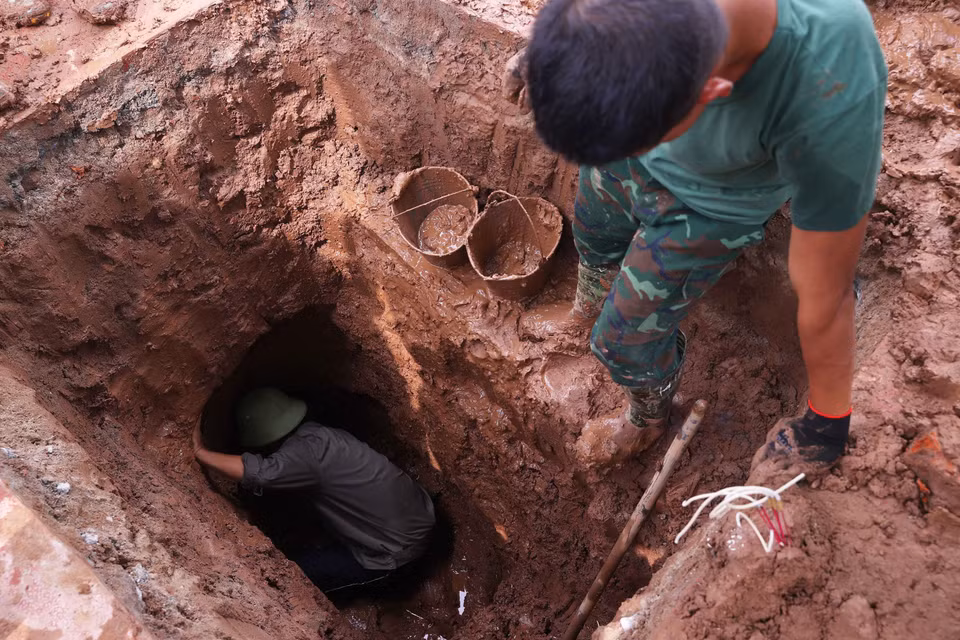 Khai quật hài cốt liệt sỹ chưa xác định danh tính tại Nghĩa trang Mai Dịch (phường Phú Diễn). (Ảnh: Văn Điệp/TTXVN)