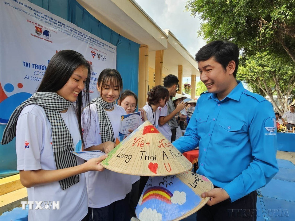 Phó Chủ tịch Hội LHTN Việt Nam tỉnh Bến Tre Trần Kim Phẳng tặng quà lưu niệm cho sinh viên Đại học Quốc gia Singapore tham gia thực hiện các hoạt động an sinh xã hội tại tỉnh năm 2024. (Ảnh: Chương Đài/TTXVN)