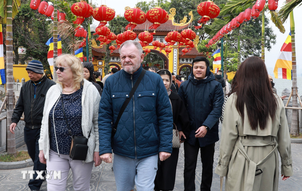 Ngưởi nước ngoài đang sống và làm việc tại Hà Nội cũng hoà mình vào dòng người Việt đi lễ đầu năm tại chùa Quán Sứ sáng mùng 1 Tết Ất Tỵ. (Ảnh: Quốc Khánh/TTXVN)