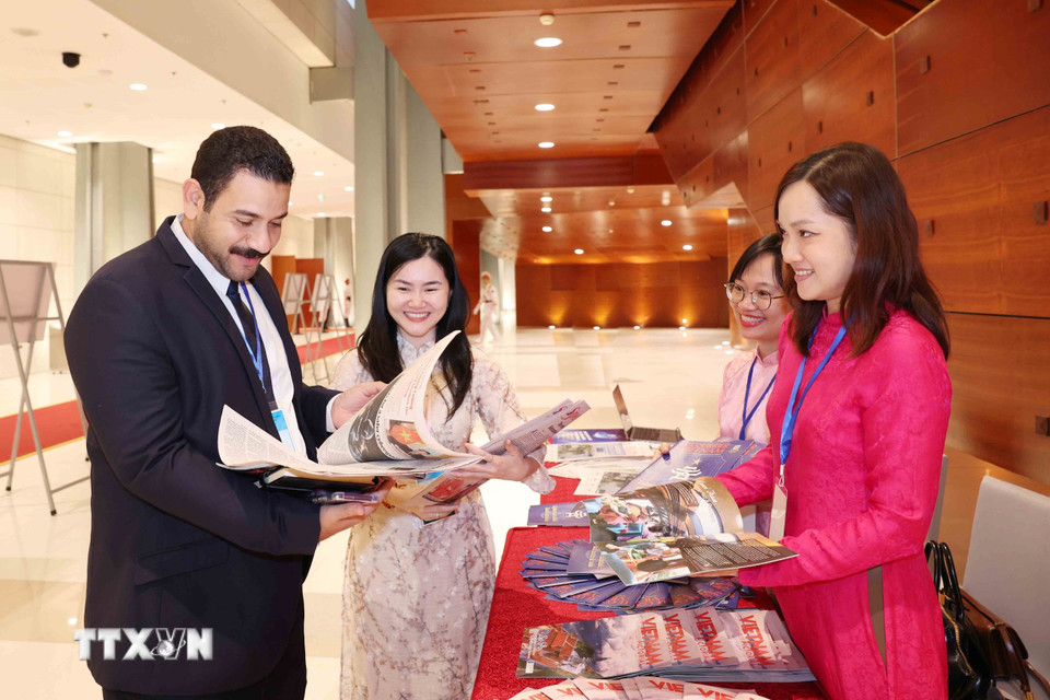 Đại biểu quốc tế tham quan, tìm hiểu các ấn phẩm báo chí của Thông tấn xã Việt Nam. (Ảnh: Phương Hoa/TTXVN)