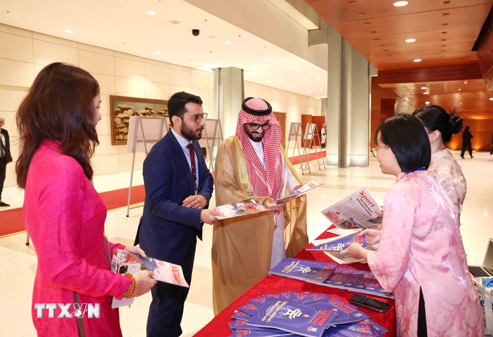 Đại biểu quốc tế tham quan, tìm hiểu các ấn phẩm báo chí của Thông tấn xã Việt Nam. (Ảnh: Phương Hoa/TTXVN)