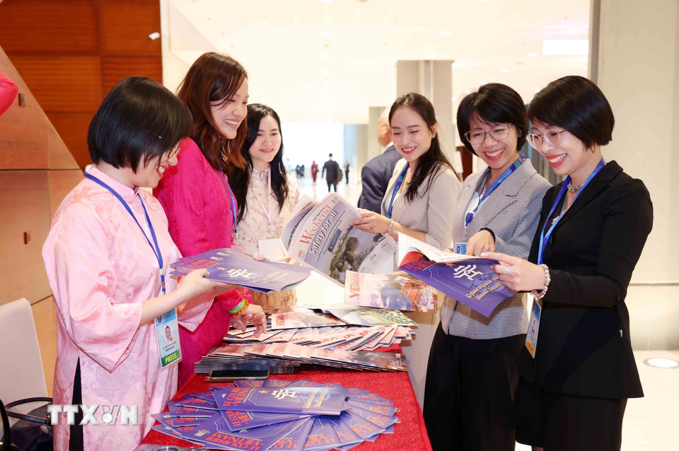 Đại biểu quốc tế tham quan, tìm hiểu các ấn phẩm báo chí của Thông tấn xã Việt Nam. (Ảnh: Phương Hoa/TTXVN)