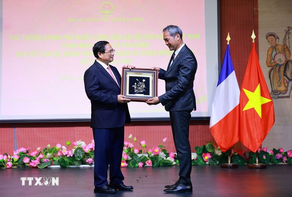 Thủ tướng Phạm Minh Chính tặng quà cho đại diện cộng đồng người Việt Nam tại Pháp. (Ảnh: Dương Giang/TTXVN)