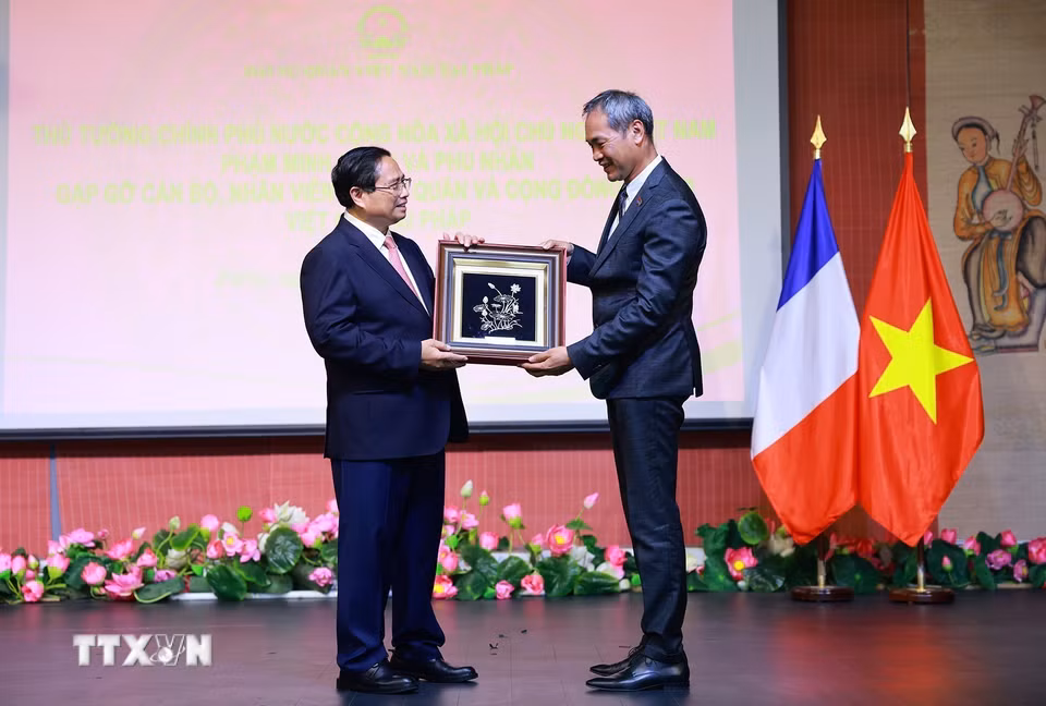 Thủ tướng Phạm Minh Chính tặng quà cho đại diện cộng đồng người Việt Nam tại Pháp. (Ảnh: Dương Giang/TTXVN)