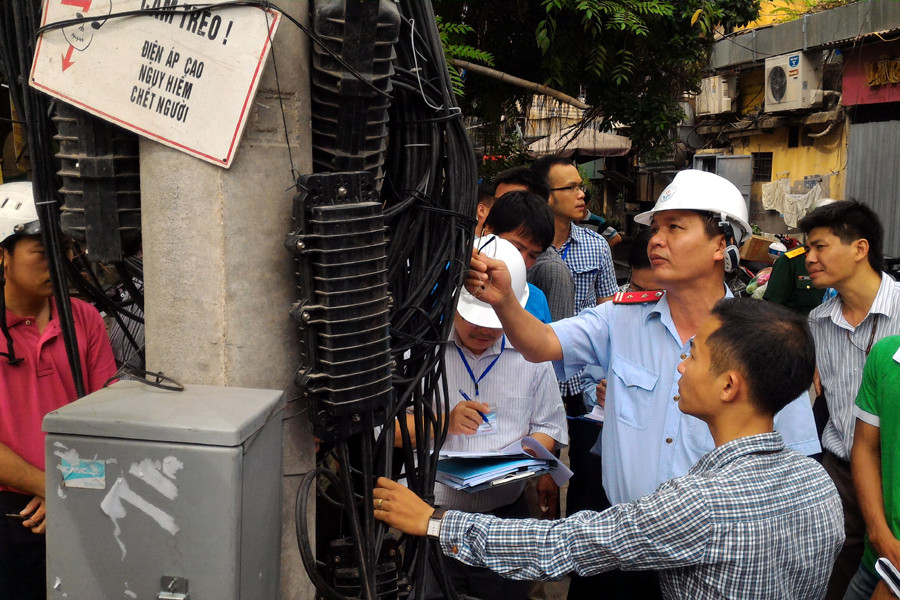 Trưởng đoàn thanh tra Nguyễn Văn Minh (đội mũ) kiểm tra việc chấp hành quy định của doanh nghiệp. (Ảnh: Trung Hiền/Vietnam+)