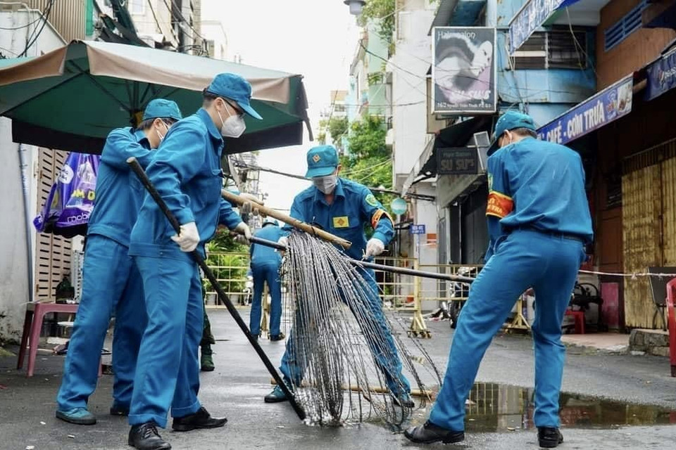 Các lực lượng thu dọn rào chắn trên đường Nguyễn Thiện Thuật (Quận 3, Thành phố Hồ Chí Minh). (Ảnh: Hồng Giang/TTXVN)