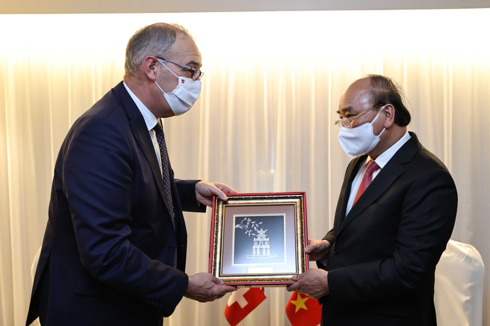 Chủ tịch nước Nguyễn Xuân Phúc tặng Tổng thống Thụy Sĩ Guy Parmelin quà lưu niệm. (Ảnh: Thống Nhất/TTXVN)
