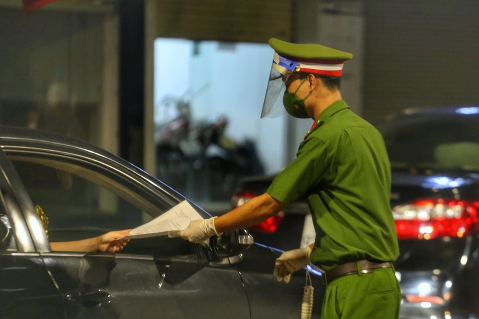 Tổ công tác của công an quận Hoàn Kiếm kiểm tra giấy đi đường của người tham gia giao thông. (Ảnh: Tuấn Đức/TTXVN)