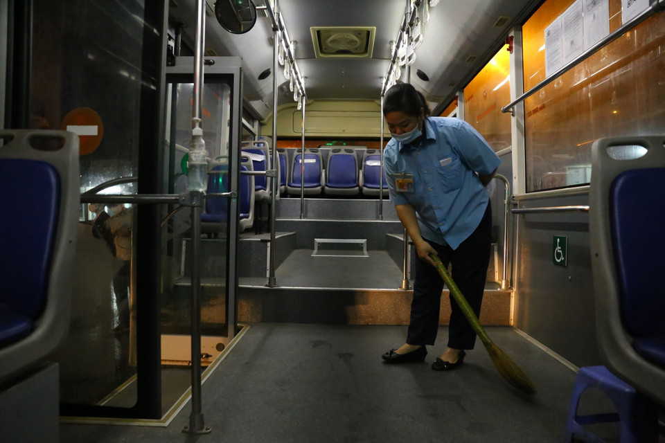 Phụ xe Nguyễn Ngọc Hường (xe 100 tuyến Đặng Xá-Long Biên) vệ sinh xe trước khi xuất bến. (Ảnh: Hoàng Hiếu/TTXVN)