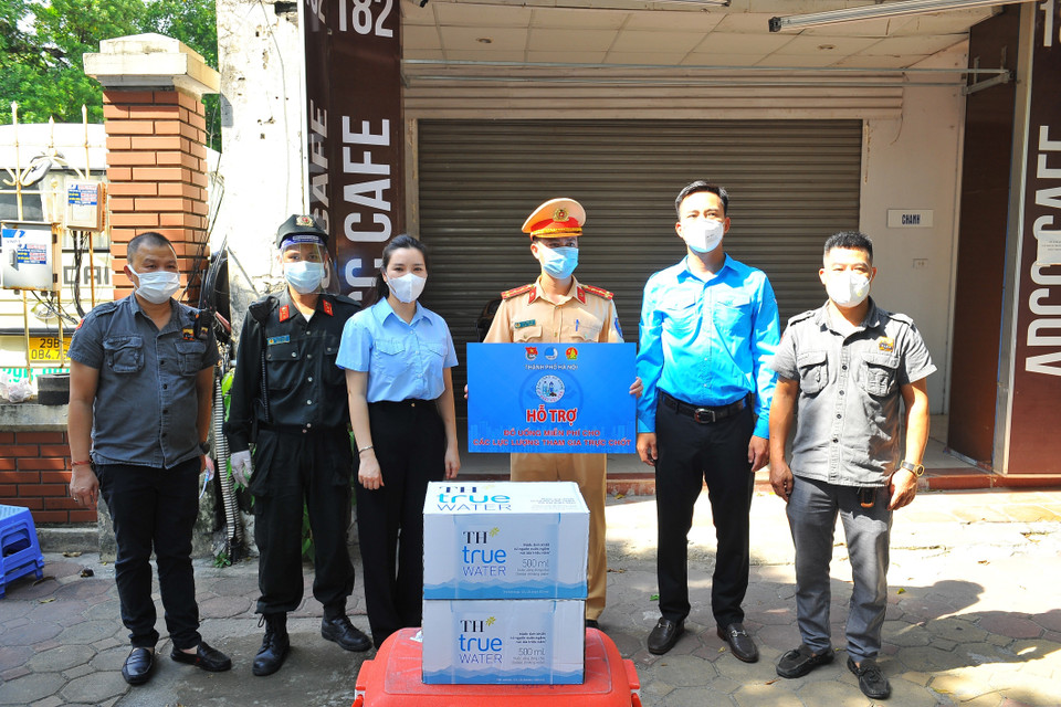 Trao tặng đồ uống cho lực lượng công an Thủ đô đang thực hiện nhiệm vụ tại 6 tổ tuần tra kiểm soát lưu động trên các tuyến đường. (Ảnh: Minh Đức/TTXVN)