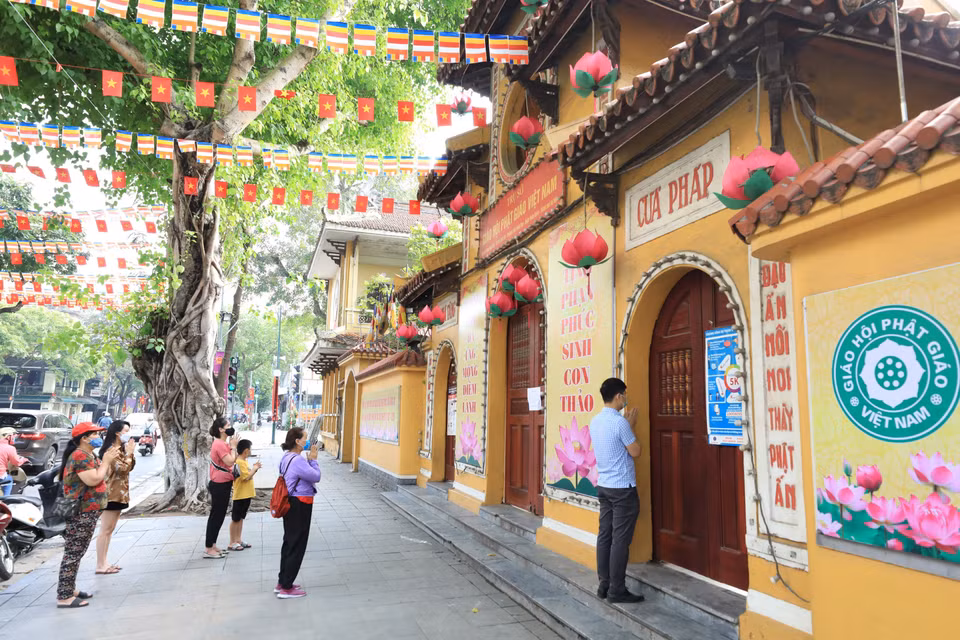 Người dân và phật tử thành tâm vái vọng bên ngoài chùa Quán Sứ. (Ảnh: Minh Đức/TTXVN)