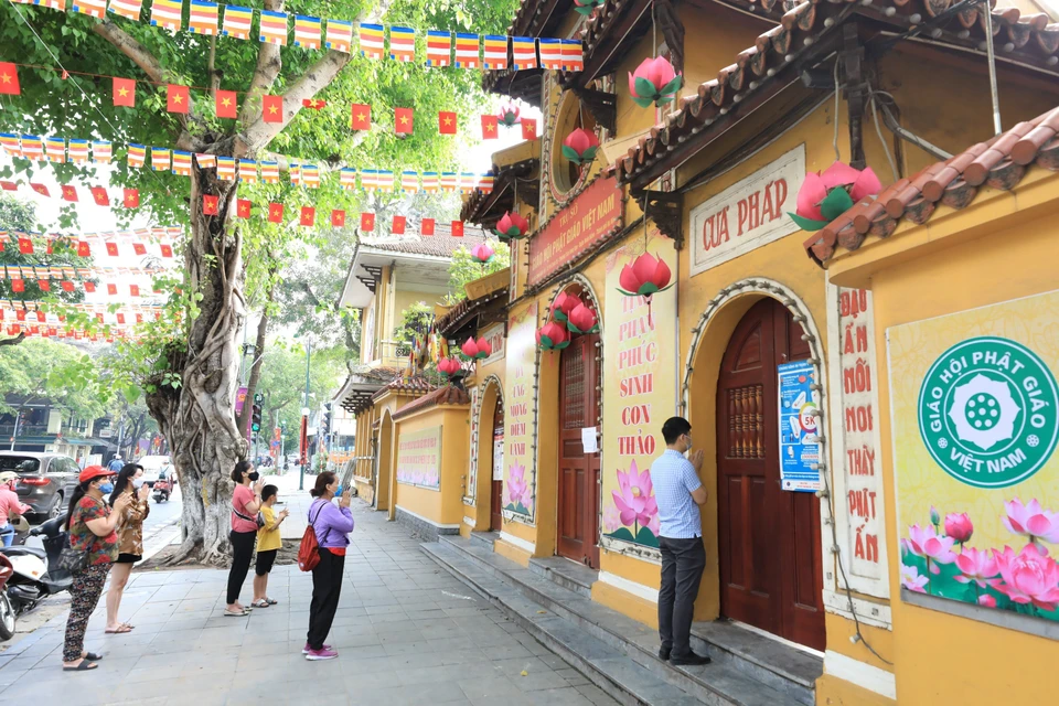 Người dân và phật tử thành tâm vái vọng bên ngoài chùa Quán Sứ. (Ảnh: Minh Đức/TTXVN)