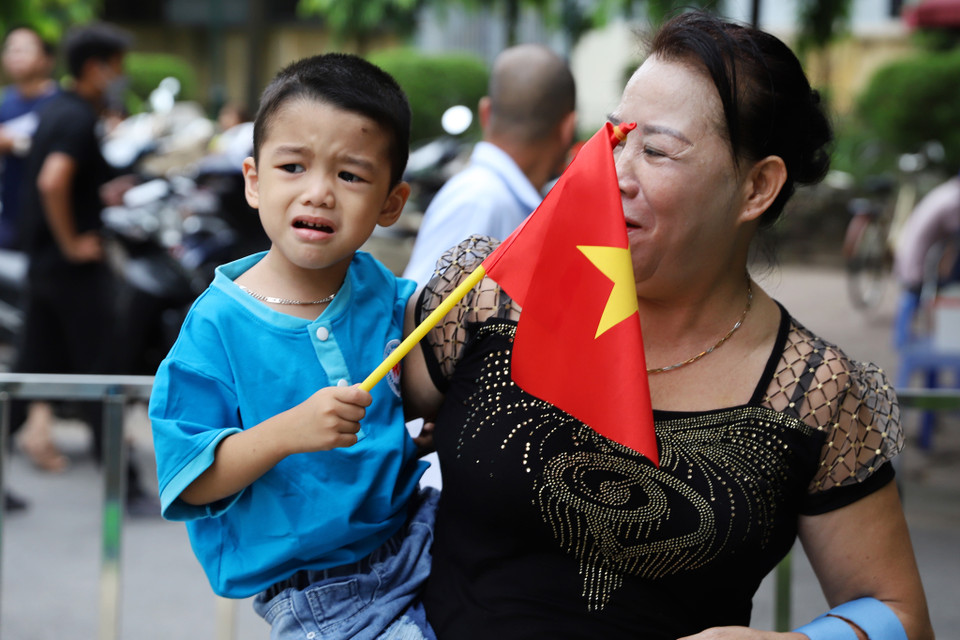 Nhiều bạn nhỏ lạ trường, lạ lớp nên chưa sẵn sàng rời khỏi vòng tay phụ huynh, lo âu trước không khí nhộn nhịp của buổi khai giảng đầu đời. (Ảnh: Hoài Nam/Vietnam+)