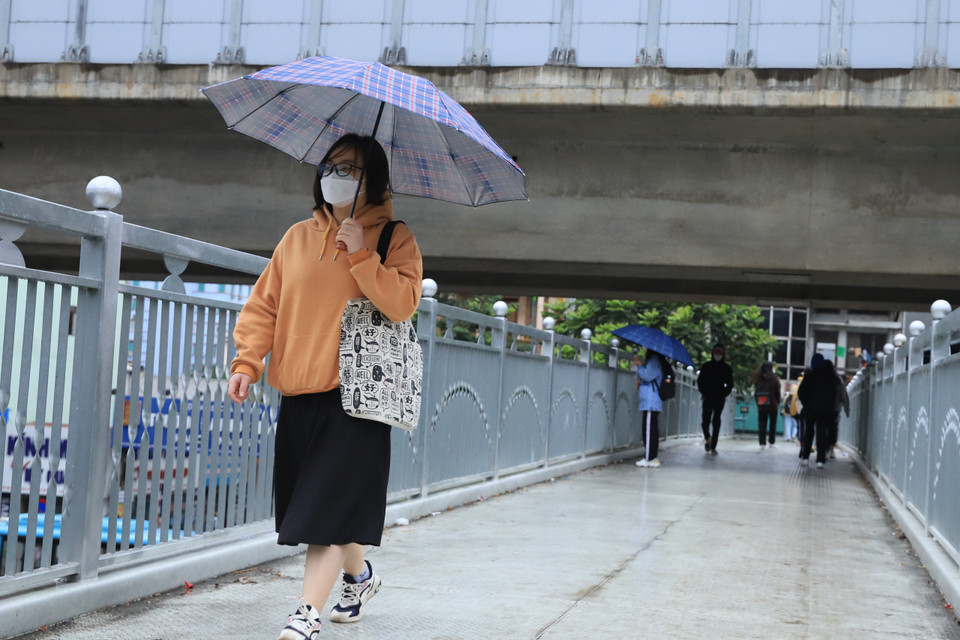 Nhiều người đã mặc thêm quần áo ấm khi nhiệt độ giảm mạnh. (Ảnh: Hoài Nam/Vietnam+)