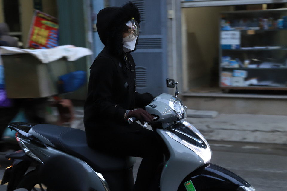 Nhiều bạn trẻ đã trang bị thêm nhiều lớp áo ấm khi phải di chuyển ra ngoài trời. (Ảnh: Hoài Nam/Vietnam+)