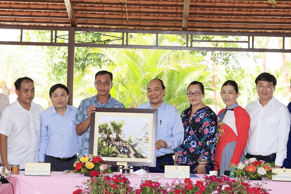 Chủ tịch nước Nguyễn Xuân Phúc tặng quà lưu niệm cho Hội quán “Cùng nhau làm du lịch.” (Ảnh: Thống Nhất/TTXVN) 