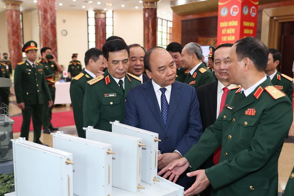 Chủ tịch nước Nguyễn Xuân Phúc được giới thiệu về sản phẩm khoa học, công nghệ lĩnh vực quân sự, quốc phòng. (Ảnh: Trọng Đức/TTXVN)