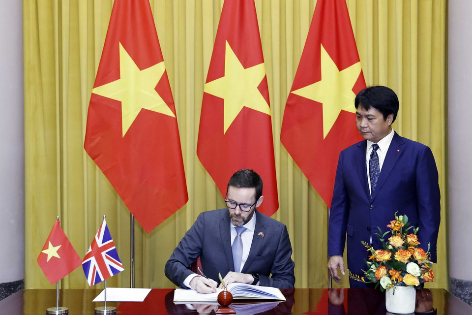 Đại sứ Liên hiệp Vương quốc Anh và Bắc Ireland Iain Frew viết lưu bút. (Ảnh: Thống Nhất/TTXVN)