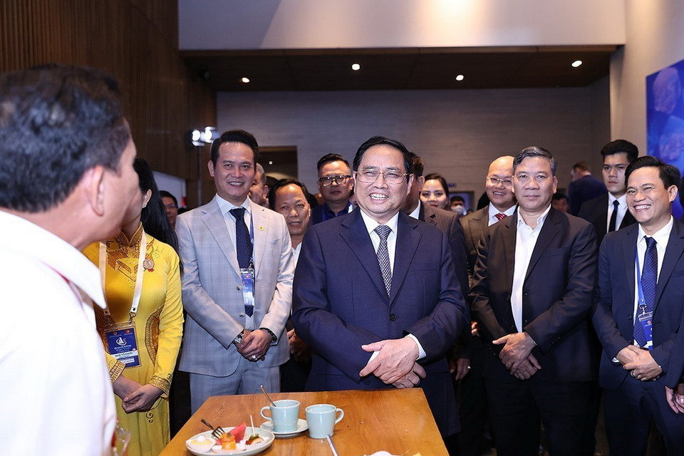 Thủ tướng Phạm Minh Chính vui vẻ trao đổi với các đại biểu dự Diễn đàn Kinh tế Việt Nam lần thứ tư. (Ảnh: Dương Giang/TTXVN)