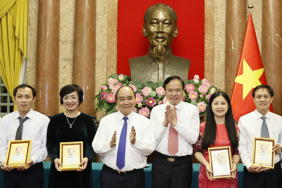 Chủ tịch nước Nguyễn Xuân Phúc tặng chân dung Chủ tịch Hồ Chí Minh cho cán bộ, công nhân lao động tiêu biểu ngành Dầu khí. (Ảnh: Thống Nhất/TTXVN)