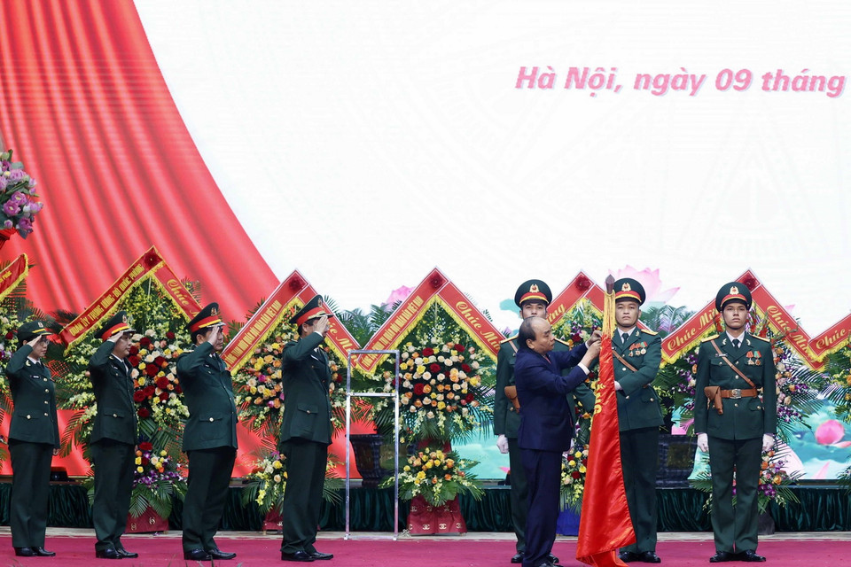 Chủ tịch nước Nguyễn Xuân Phúc gắn Huân chương Bảo vệ Tổ quốc hạng Ba lên lá cờ truyền thống của Binh đoàn 11. (Ảnh: Thống Nhất/TTXVN)