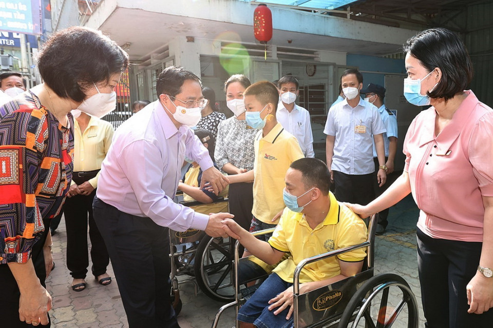 Thủ tướng Phạm Minh Chính động viên các em đang được nuôi dưỡng, chăm sóc tại Trung tâm Bảo trợ trẻ tàn tật mồ côi Thị Nghè. (Ảnh: Dương Giang/TTXVN)