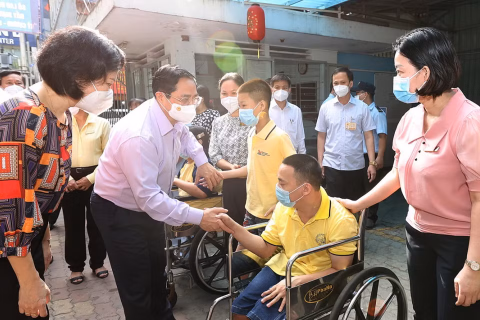 Thủ tướng Phạm Minh Chính động viên các em đang được nuôi dưỡng, chăm sóc tại Trung tâm Bảo trợ trẻ tàn tật mồ côi Thị Nghè. (Ảnh: Dương Giang/TTXVN)
