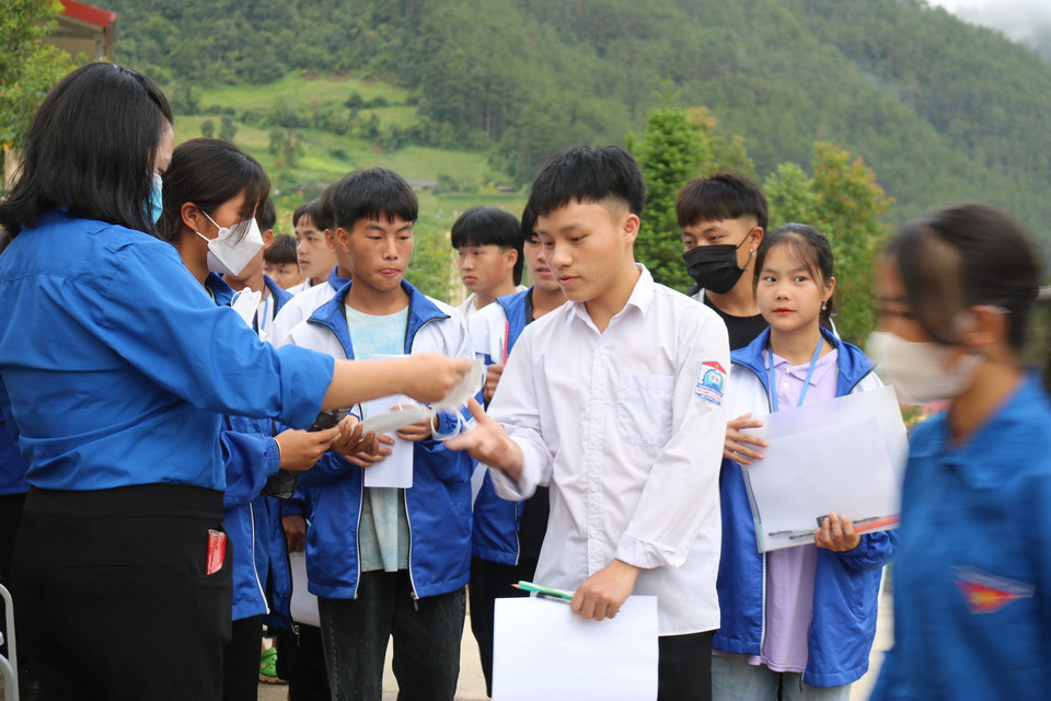  Các tình nguyện viên phát khẩu trang cho các thí sinh đến thi tại điểm thi Trường THCS và THPT xã Púng Luông, huyện Mù Cang Chải, tỉnh Yên Bái. (Ảnh: Việt Dũng/TTXVN)