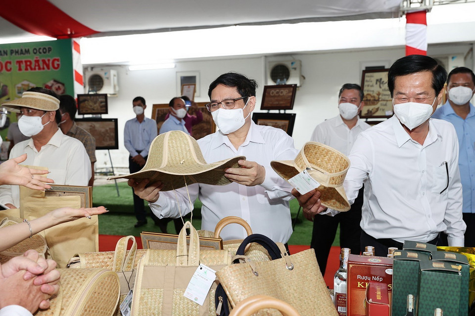 Thủ tướng Phạm Minh Chính xem các sản phẩm thủ công trưng bày. (Ảnh: Dương Giang/TTXVN)