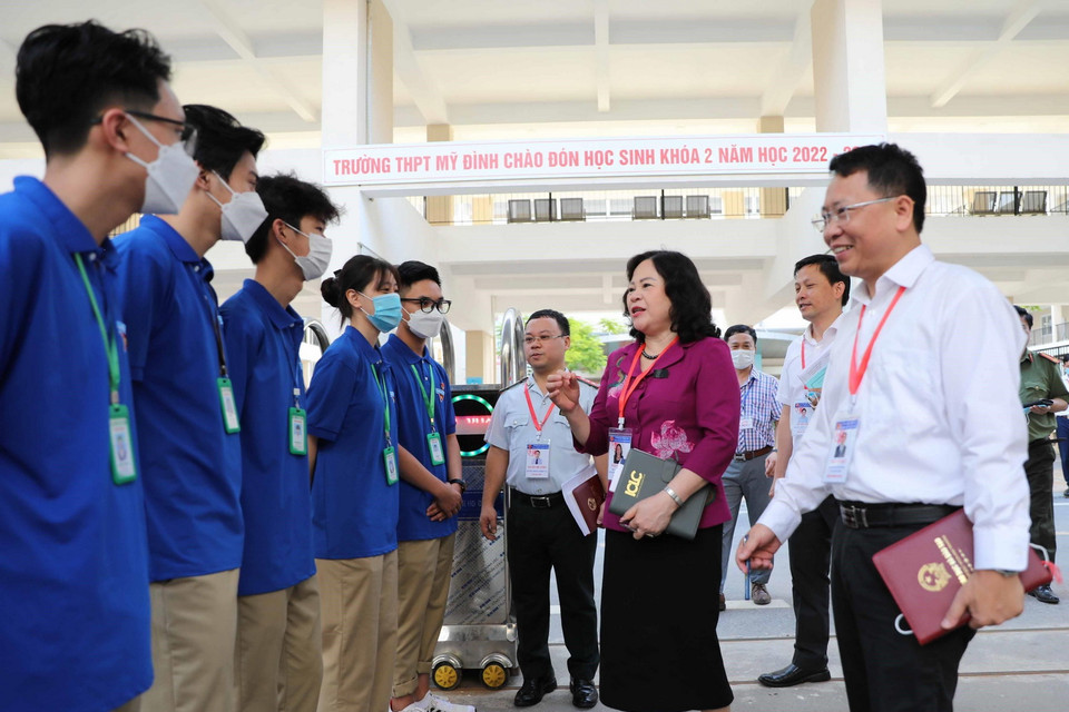Thứ trưởng Bộ Giáo dục và Đào tạo Ngô Thị Minh hỏi thăm, động viên các tình nguyện viên tại điểm thi trường THPT Mỹ Đình, Hà Nội. (Ảnh: Thanh Tùng/TTXVN)