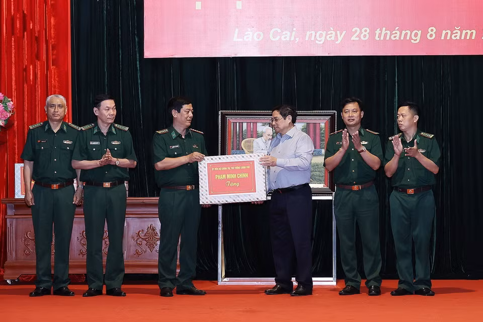 Thủ tướng Phạm Minh Chính tặng quà cho cán bộ, chiến sỹ Bộ Chỉ huy Bộ đội Biên phòng tỉnh Lào Cai. (Ảnh: Dương Giang/TTXVN)