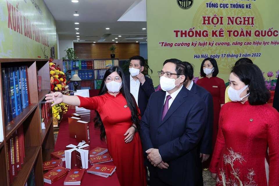 Nhân viên ngành thống kê giới thiệu với Thủ tướng Phạm Minh Chính về sách, hình ảnh, hiện vật của ngành thống kê. (Ảnh: Dương Giang/TTXVN)