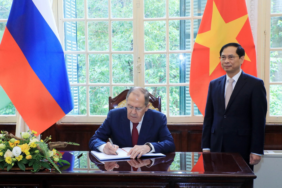Bộ trưởng Ngoại giao Bùi Thanh Sơn chứng kiến Bộ trưởng Ngoại giao Nga Sergey Lavrov ghi lưu bút. (Ảnh: Lâm Khánh/TTXVN)