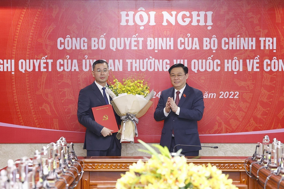 Chủ tịch Quốc hội Vương Đình Huệ trao Nghị quyết của Ủy ban Thường vụ Quốc hội và tặng hoa ông Ngô Văn Tuấn. (Ảnh: Doãn Tấn/TTXVN)