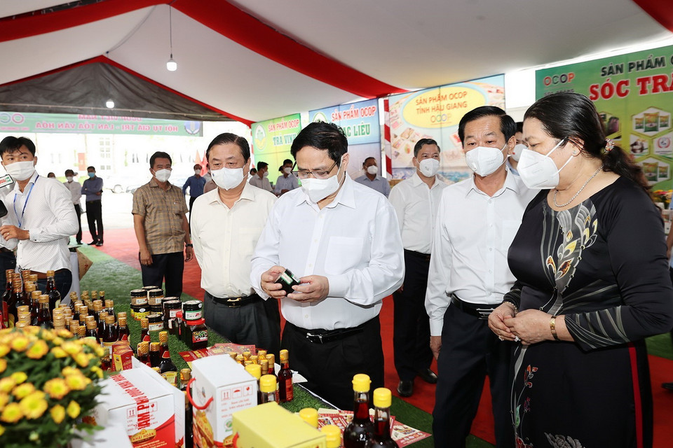 Thủ tướng Phạm Minh Chính xem các sản phẩm nông nghiệp được trưng bày. (Ảnh: Dương Giang/TTXVN)