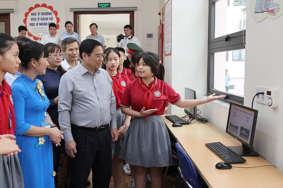 Thủ tướng Phạm Minh Chính nghe học sinh giới thiệu về cơ sở vật chất cụm liên trường học thành phố Lào Cai. (Ảnh: Dương Giang/TTXVN)