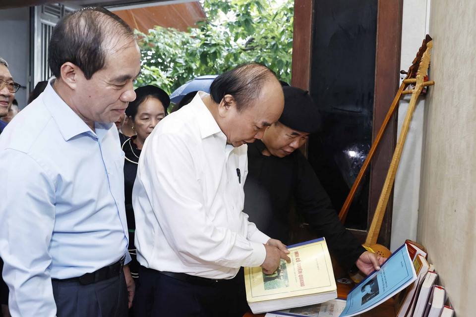 Chủ tịch nước Nguyễn Xuân Phúc cùng Đoàn công tác thăm Nghệ nhân Ưu tú Ma Văn Đức ở phường Tân Hà, thành phố Tuyên Quang. (Ảnh: Thống Nhất/TTXVN)