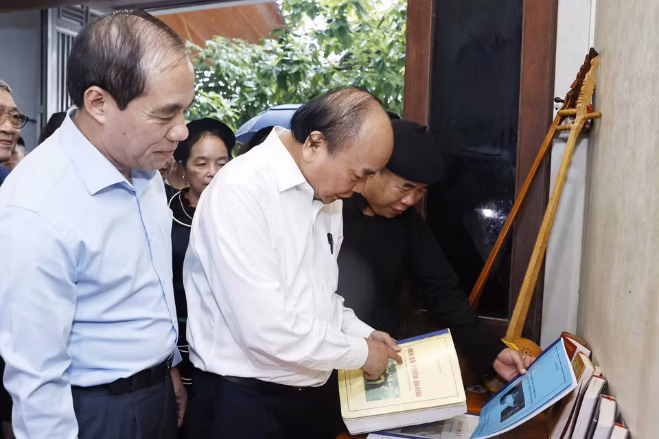 Chủ tịch nước Nguyễn Xuân Phúc cùng Đoàn công tác thăm Nghệ nhân Ưu tú Ma Văn Đức ở phường Tân Hà, thành phố Tuyên Quang. (Ảnh: Thống Nhất/TTXVN)