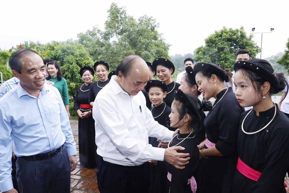 Chủ tịch nước Nguyễn Xuân Phúc nói chuyện với các thành viên Câu lạc bộ hát Then thôn Tân Lập, xã Tân Trào, huyện Sơn Dương, tỉnh Tuyên Quang. (Ảnh: Thống Nhất/TTXVN)