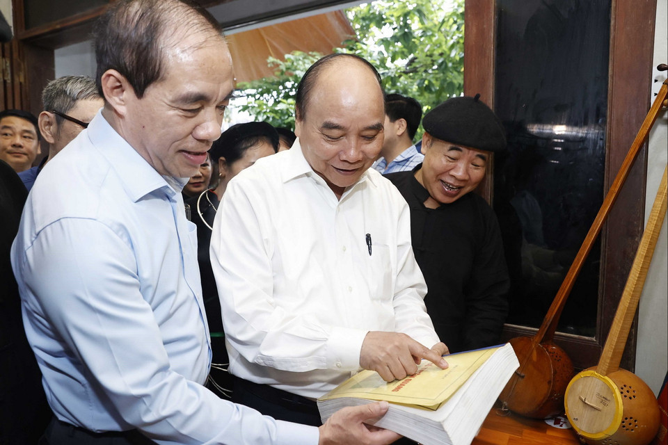 Chủ tịch nước Nguyễn Xuân Phúc thăm Nghệ nhân Ưu tú Ma Văn Đức ở phường Tân Hà, thành phố Tuyên Quang. (Ảnh: Thống Nhất/TTXVN)