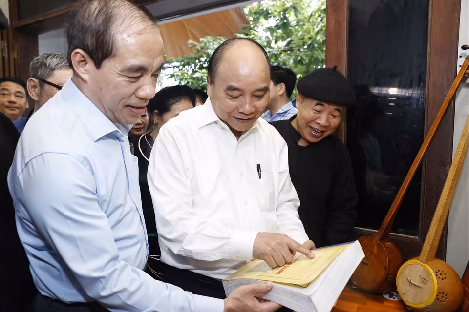 Chủ tịch nước Nguyễn Xuân Phúc thăm Nghệ nhân Ưu tú Ma Văn Đức ở phường Tân Hà, thành phố Tuyên Quang. (Ảnh: Thống Nhất/TTXVN)