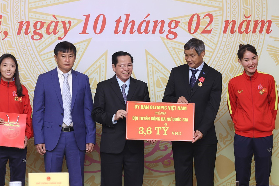  Đại diện Ủy ban Olympic Việt Nam tặng biểu trưng số tiền 3,6 tỷ đồng cho Đội tuyển Bóng đá Nữ Quốc gia Việt Nam. (Ảnh: Dương Giang/TTXVN)
