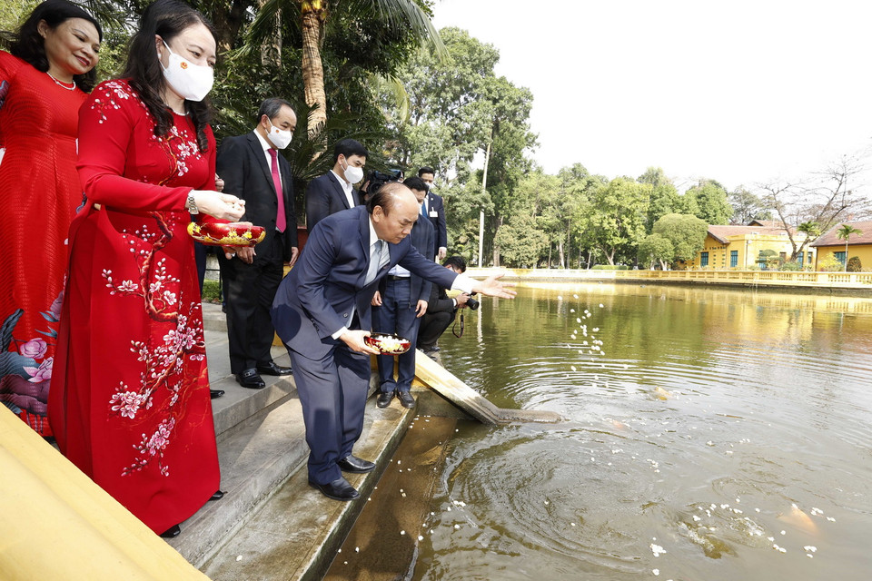 Chủ tịch nước Nguyễn Xuân Phúc cho cá ăn trong trong Khu Di tích Chủ tịch Hồ Chí Minh ở Phủ Chủ tịch. (Ảnh: Thống Nhất/TTXVN)
