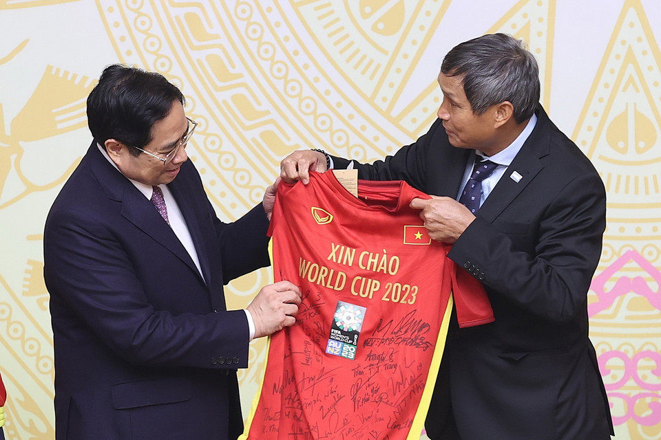  Huấn luyện viên Mai Đức Chung đại diện Đội bóng đá Nữ Việt Nam tặng quà lưu niệm cho Thủ tướng Phạm Minh Chính. (Ảnh: Dương Giang/TTXVN)