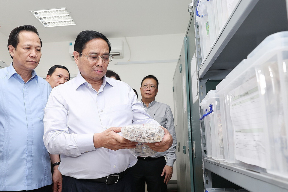 Thủ tướng Phạm Minh Chính xem quy trình bảo quản mẫu hài cốt liệt sỹ. (Ảnh: Dương Giang/TTXVN)